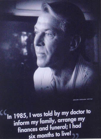 AIDS 2006: Canada Booth - Bradford McIntyre, living with HIV, 8 ft. Poster Portrait, providing a human FACE to HIV/AIDS in Canada in 2006. Exhibition Hall at the XVI International AIDS Conference, August 13 - 18, 2006, Toronto, Canada. Poster caption - In 1985, I was told by my doctor to arrange my finances and funeral; I had six months to live. August 13 - 18, 2006, Toronto, Canada