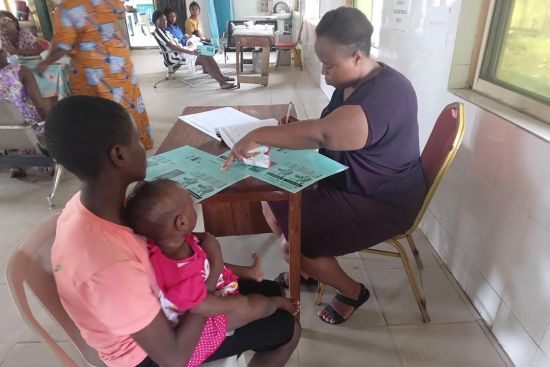 Adetunji Bimpe and her daughter being attended to by immunisation staff. Credit: Ijeoma Ukazu