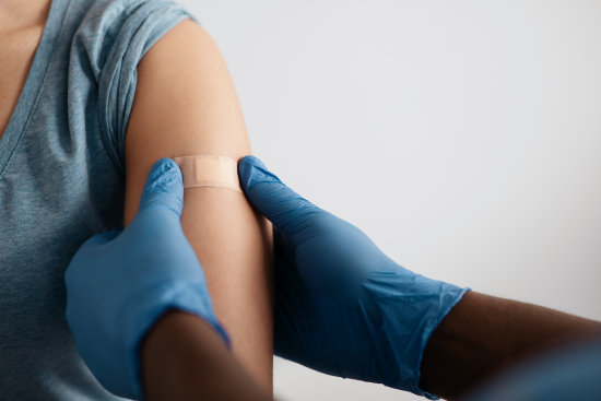 A band-aid is applied to an arm aftetr a vaccine has been administered