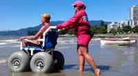 Bradford McIntyre demonstrating Accessible Beach Feature: beach access with a beach wheelchair - English Bay Beach, Vancouver, BC. Canada. August 2, 2012 - Photo Credit: City of Vancouver