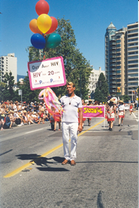 Photo 2004: Bradford McIntyre, living with since 1984, is Out About HIV in the Vancouver Pride Parade: Vancouver Pride Parade, 2004 - In the Name of Love. OUT and PROUD, Bradford McIntyre marches proudly in the 2004 Pride Parade with his homemade sign, OUT ABOUT HIV - HIV+ FOR 20 YEARS. Vancouver, Canada. Photo Credit: Deni Daviau