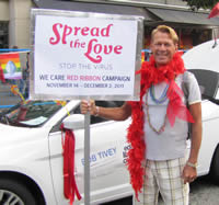 Bradford McIntyre, HIV-positive since 1984, and Director, Board of Directors, AIDS Vancouver, holding AIDS Vancouver's We Care Red Ribbon Campaign sign: Spread the Love STOP THE VIRUS, in the Vancouver Pride Parade, 2011.