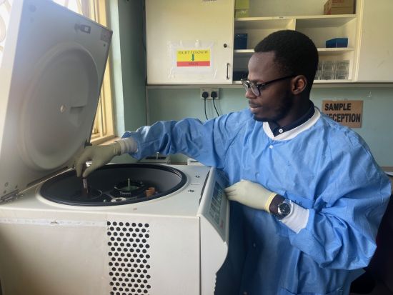 Brian Lubega, a laboratory technologist at Joint Clinical Research Centre in Uganda, tests samples in a centrifuge. (Jeff Renaud/Western Communications)