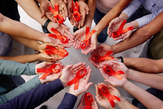 Photo: A circle of hands, all skin colors, holding red ribbons symbolizing HIV/AIDS. GettyImages A circle of hands, all skin colors, holding red ribbons symbolizing HIV/AIDS. GettyImages
