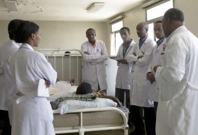 Photo: Ethiopian Medical Students Gather and Discuss around Patient Bed in Hospital