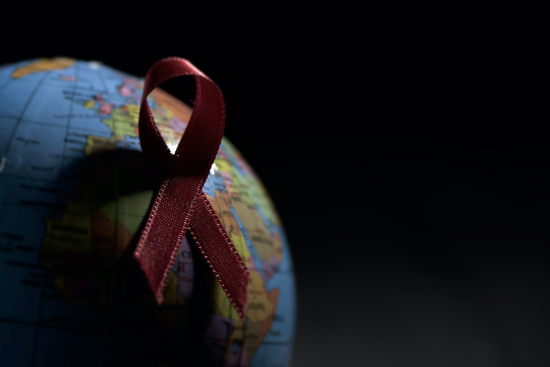 Globe with red ribbon on black background