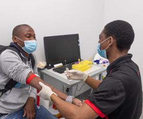 Kabelo Mabeleng prepares Duglas Netshidzivhani for a vaccine trial at the Aurum Institute Rustenberg, South Africa. Credit: Mwangi Kirubi