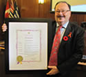 Brian Chittock, Executive Director of AIDS Vancouver holds Red Ribbon Month proclamation. Positive Change Red Ribbon Campaign. November 1, 2011 - www.aidsvancouver.org