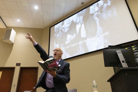 Binghamton University alumnus Ron Goldberg, author of 'Boy with the Bullhorn: A Memoir and History of ACT UP New York,' reads from his book at Symposium Hall at the Center of Excellence at the Innovative Technologies Complex, October 24, 2022. Image Credit: Jonathan Cohen. Binghamton University alumnus Ron Goldberg, author of Boy with the Bullhorn: A Memoir and History of ACT UP New York