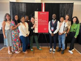 The SUSTAIN Center at UH team photographed with the cover of an exclusive supplemental issue of Meharry Medicals Journal of Health Care for the Poor and Underserved, titled “The Gilead COMPASS Initiative: Navigating HIV in the Southern U.S. by Building Capacity & Bridging Communities.”