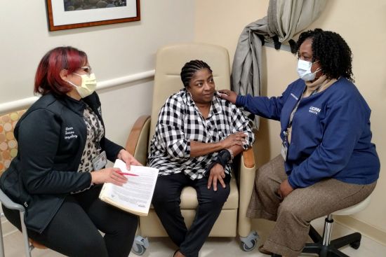 Eileen Torres Gonzalez (left) and Dezrene Atkinson (right) speak with patient Annamarie Shand in UConn Healths infectious diseases clinic. Dezrene will check in with patients at each scheduled clinic visit to ensure the patients understand their plan of care, address current or new barriers, and make appropriate referrals to the care team, says assistant nurse manager Amy Clark. She continues to build relationships with old and new patients in order to keep them in care and healthy. (Photo by Chris DeFrancesco)