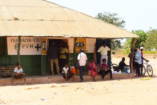 people near a pharmacy in a village