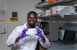 Seye Oladeji with an example of a detection assay. Credit: Rice University/Jared Jones.